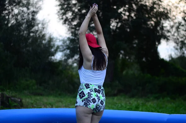 Hermosa chica de tamaño más húmedo en la piscina, al atardecer —  Fotos de Stock