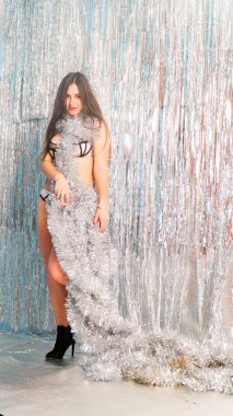 Stüdyoda poz veren parlak noel süsleriyle güzel seksi kadın, tatil konsepti.   