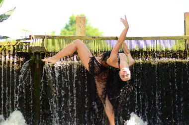 Genç esmer model bir şelale karşı poz