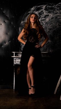 Stüdyoda poz veren narin siyah elbiseli kadın.  