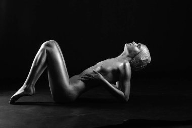 Gümüş rengi vücut boyalı genç atletik kadın.