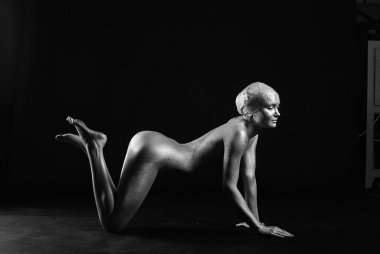 Gümüş rengi vücut boyalı genç atletik kadın.