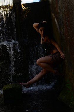Genç esmer model bir şelale karşı poz