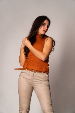 Güzel esmer model, karanlık odada poz veriyor. 