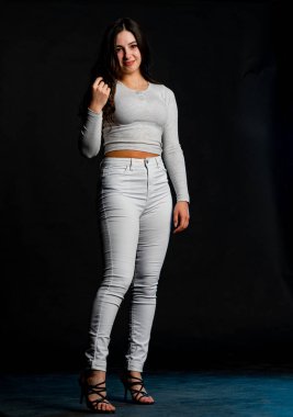 Saçları topuz şeklinde olan genç bayan kollarını kavuşturup yukarı bakıyor. Gri elbiseli, ısıran dudakları olan, arzularını düşünen kaprisli kadın manken. Hayal dünyası konsepti