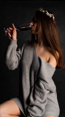 Güzel seksi kız, kısa gri bir elbise, siyah arka plan koltuğu