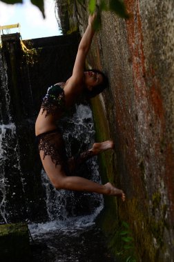 Genç esmer model bir şelale karşı poz