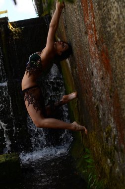 Genç esmer model bir şelale karşı poz