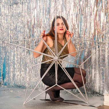 Stüdyoda poz veren parlak noel süsleriyle güzel seksi kadın, tatil konsepti.   