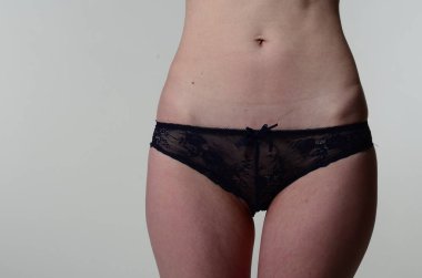 Sarı ceketli, şortlu ve topuklu ayakkabılı zarif bir kadın. Moda stüdyosu çekimi.