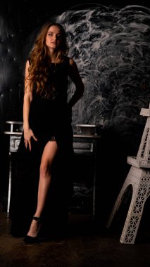 Stüdyoda poz veren narin siyah elbiseli kadın.  