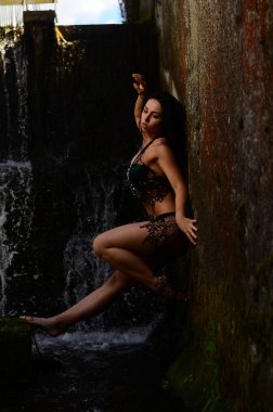 Genç esmer model bir şelale karşı poz