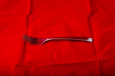 Tekstil arka planına karşı gümüş metal çatal 