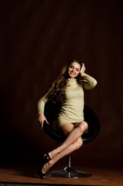 Parlak elbiseli çekici kadın siyah arka planda poz veriyor. 