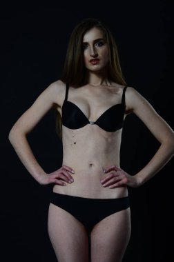 Sarı ceketli, şortlu ve topuklu ayakkabılı zarif bir kadın. Moda stüdyosu çekimi.