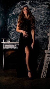 Stüdyoda poz veren narin siyah elbiseli kadın.  