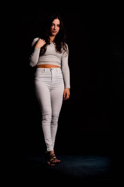 Saçları topuz şeklinde olan genç bayan kollarını kavuşturup yukarı bakıyor. Gri elbiseli, ısıran dudakları olan, arzularını düşünen kaprisli kadın manken. Hayal dünyası konsepti