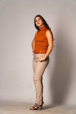 Güzel esmer model, karanlık odada poz veriyor. 