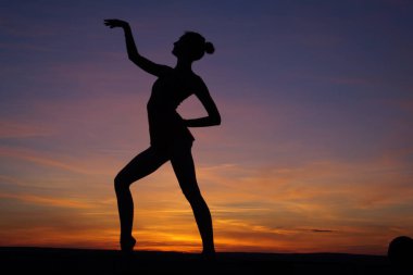 dans dansçı gün batımına karşı havada böler yok.