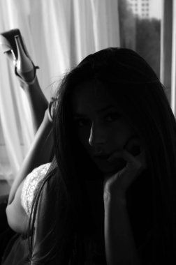 İç çamaşırlarıyla kanepede poz veren sevimli, çekici, çekici bir kızın portresi. 