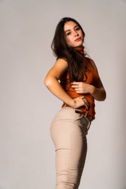 Güzel esmer model, karanlık odada poz veriyor. 