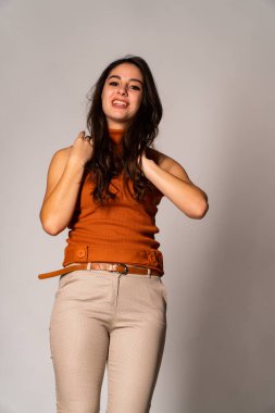 Güzel esmer model, karanlık odada poz veriyor. 