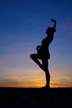 dans dansçı gün batımına karşı havada böler yok.