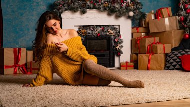 Güzel kız, şöminenin yanında poz veriyor.   