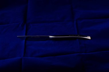 Tekstil arka planında gümüş metal bıçak 