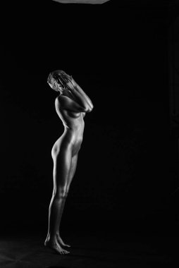 Gümüş rengi vücut boyalı genç atletik kadın.