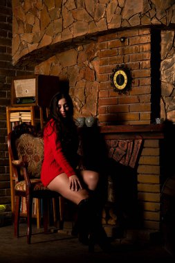 Koyu arkaplanda kırmızı kazaklı, güzel, çıplak kadın.   