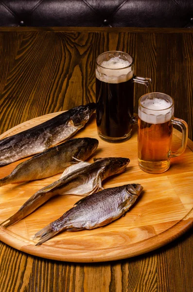 Bira bardağı, arka planda kurutulmuş balık, ahşap bir masada, kırsal bir tarzda..