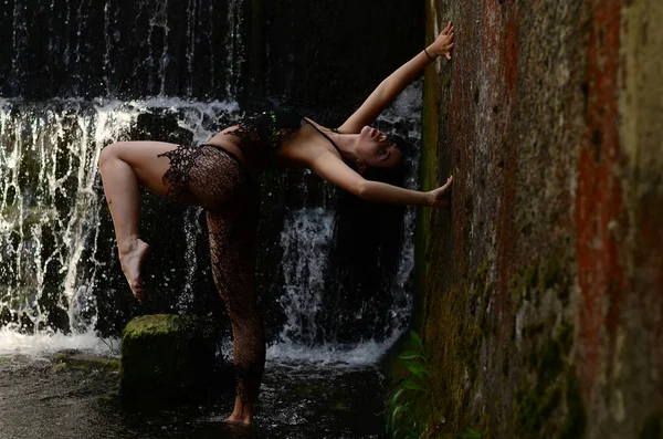 Genç esmer model bir şelale karşı poz