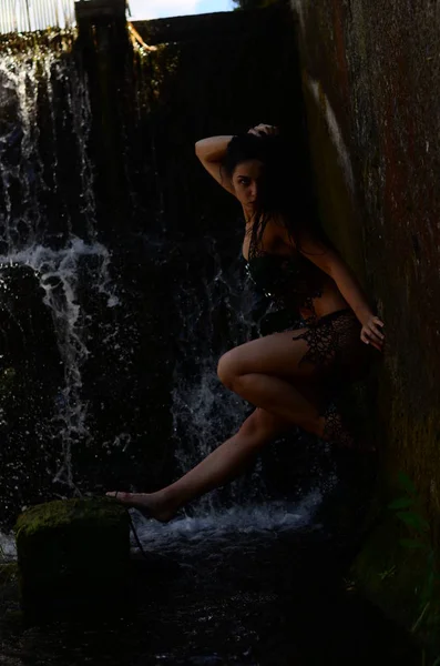 Genç esmer model bir şelale karşı poz