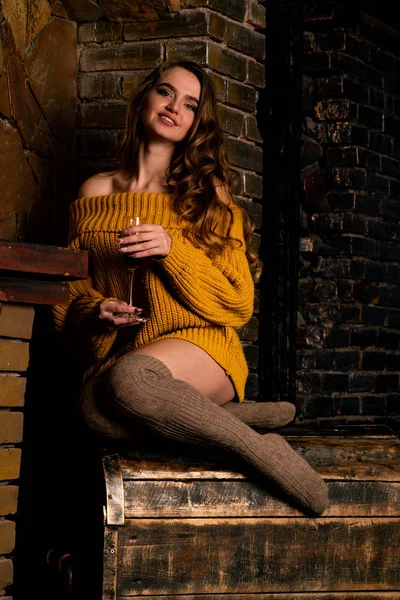 Güzel kız, şöminenin yanında poz veriyor.   