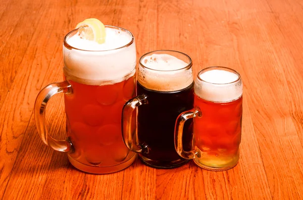Variedad de cervezas diferentes, de diferentes colores y grados alcohólicos en copas de diferentes formas adaptadas a diferentes personalidades — Foto de Stock