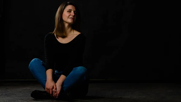 Junge schöne Frau in schwarzer Lederjacke, schwarzem Oberteil, kurzem Rock und Stiefeln, die vor schwarzem Hintergrund posieren. Studioaufnahme einer blonden Frau vor schwarzem Hintergrund — Stockfoto