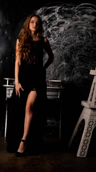 Stüdyoda poz veren narin siyah elbiseli kadın.  