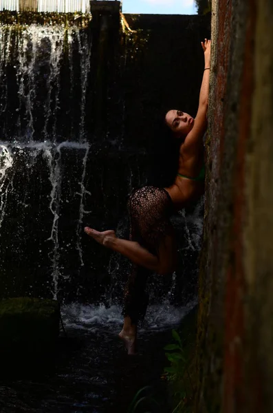 Genç esmer model bir şelale karşı poz