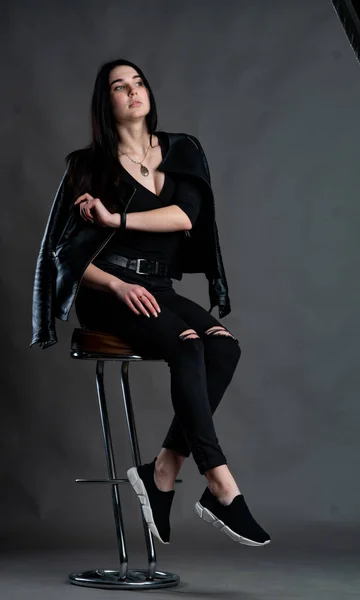 若いですブルネット女性でスタイリッシュな服でポーズでダークスタジオ — ストック写真
