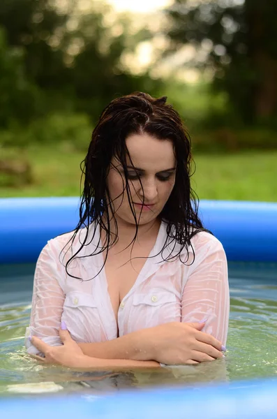 Hermosa chica de tamaño más húmedo en la piscina, al atardecer — Foto de Stock