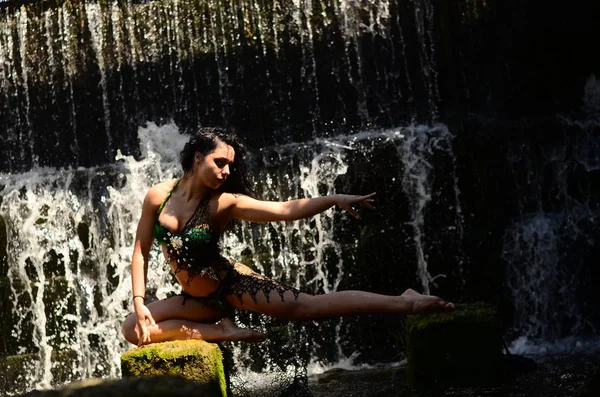 Jonge brunette model poseren tegen een waterval — Stockfoto