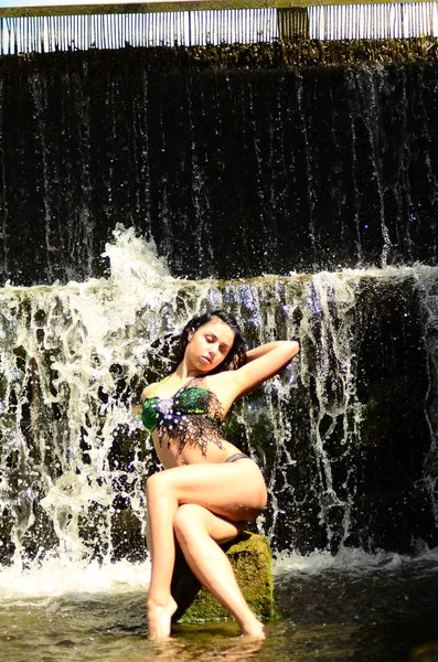 Jovem morena modelo posando contra uma cachoeira — Fotografia de Stock