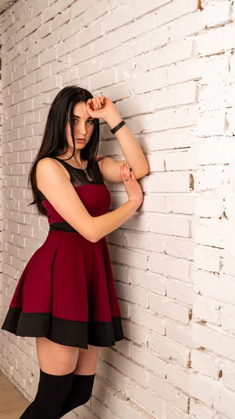 年轻性感的女模特 黑头发 穿着红色衣服 在黑暗的工作室里摆姿势 — 图库照片