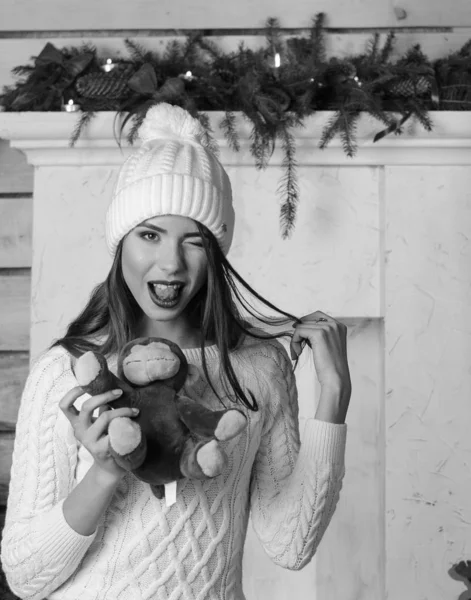 Schöne sexy Frau mit Weihnachtsbaum im Hintergrund sitzt auf eleganten Stuhl in gemütlicher Landschaft. Porträt von Mädchen posiert ziemlich kurz eng anliegendes weißes Kleid. attraktive brünette weiblich, indoor shot. — Stockfoto