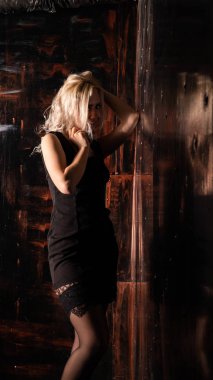 Stüdyoda poz veren güzel elbiseli hoş sarışın kadın.