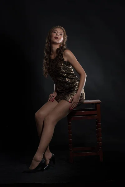 young lovely expression woman in crown posing at studio