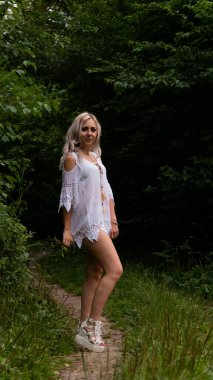 Doğada yaz elbisesi giyen seksi sarışın kadın. 