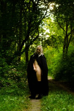 Sonbahar parkında yürüyen şık, sarışın kadın.