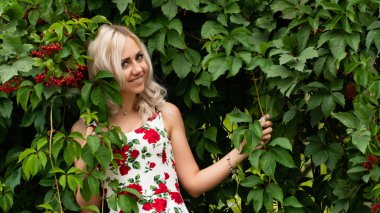 Doğada yaz elbisesi giyen seksi sarışın kadın. 